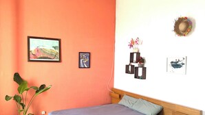 A bedroom with a bed, a potted plant, and wall decorations. - Typical Catalan house with sea view (Premià de Mar)
