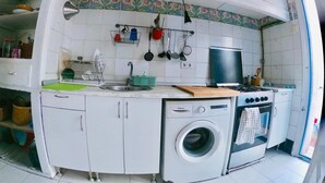 A compact kitchen with a washing machine, a stove, and a sink. - Typical Catalan house with sea view (Premià de Mar)