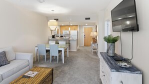 Ein modernes Wohnzimmer mit Sofa, Couchtisch und Fernseher.