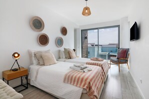 A modern bedroom with two beds, a nightstand, a chair, and a large window. - Villa 'Meluna' with Balcony, Wi-Fi and Air Conditioning (Albufeira)