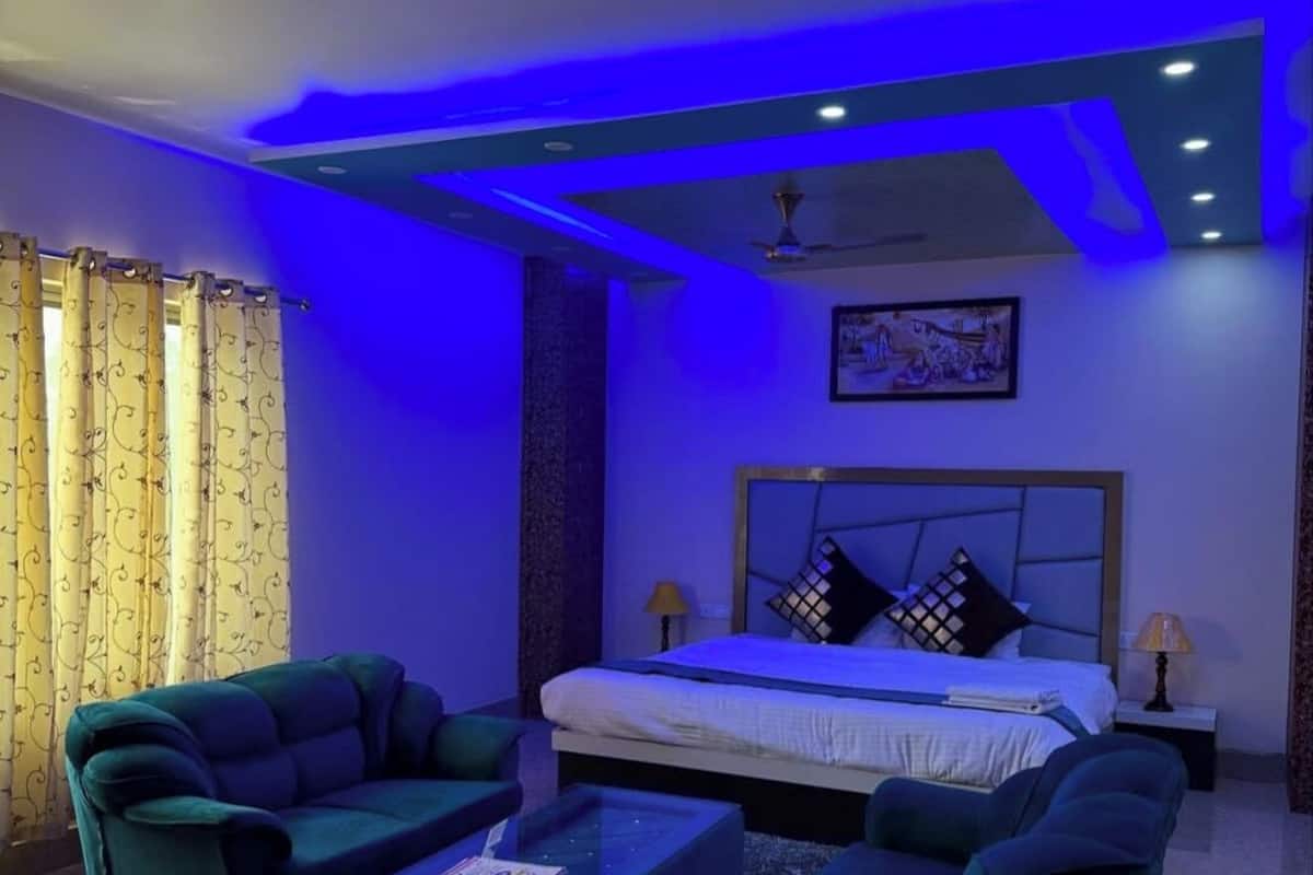 Ein modernes Schlafzimmer mit Bett, zwei Nachttischen, einem Deckenventilator und einem großen Fenster mit Vorhängen.