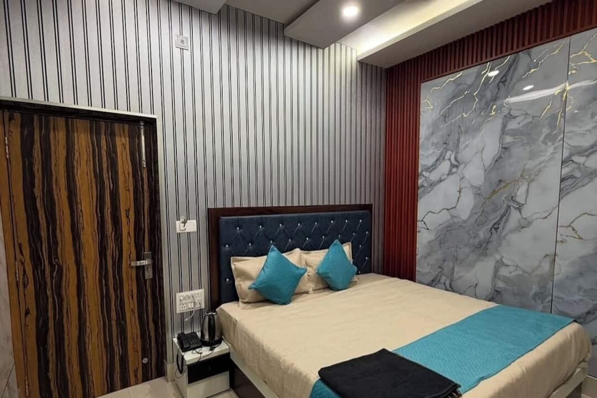 Ein modernes Schlafzimmer mit Bett, Schrank und Wandverkleidung aus Marmor.