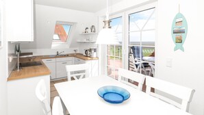 Une cuisine moderne avec des meubles blancs, un plan de travail en bois et un coin repas comprenant une table et des chaises blanches.