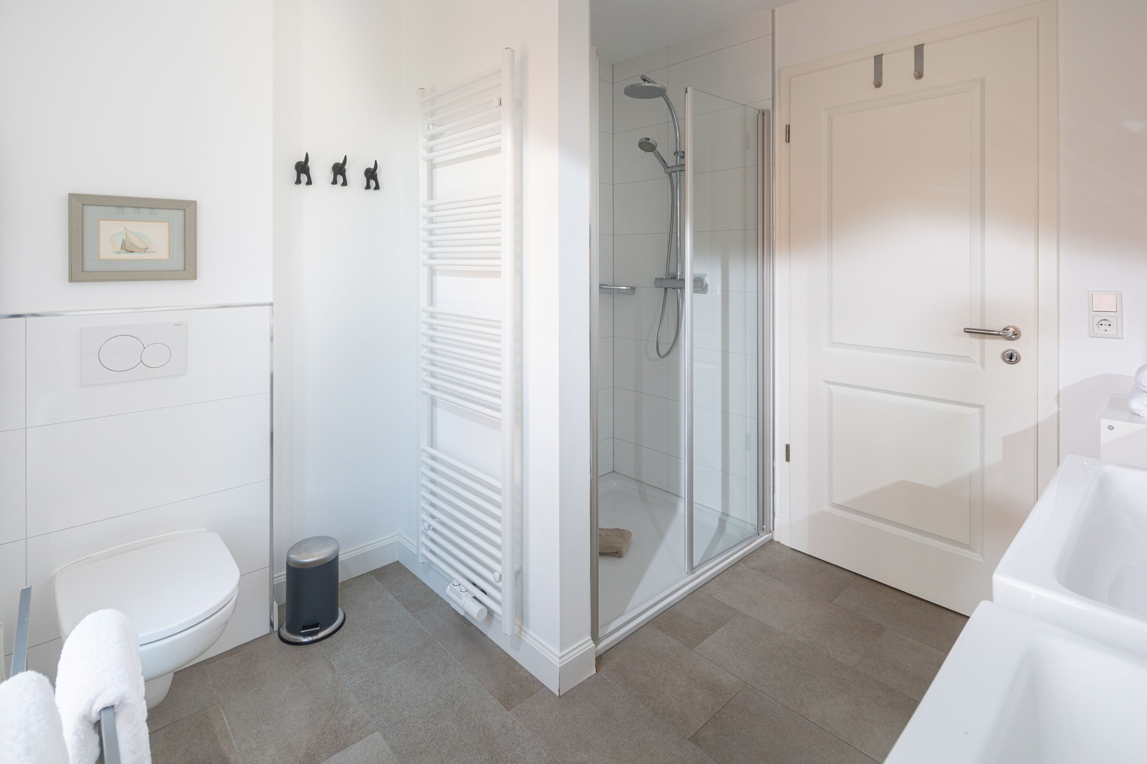 Een moderne badkamer met toilet, douche en hygiëneslot.