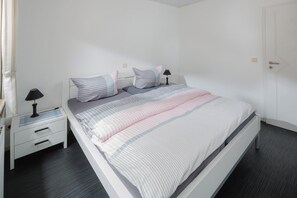 Un dormitorio moderno con cama, mesitas de noche y mesilla.