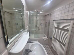 A modern bathroom with a glass-enclosed shower, a white sink, and a bathtub. - "Idyllic vacation apartment Seute Deern Kajüte - your perfect retreat on the (Juist)