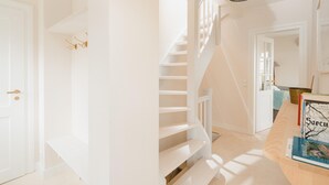 Eine Treppe mit weißen Geländern, einem Holzboden und einer Tür mit Schlüsselloch.