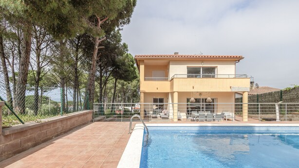 A two-story building with a swimming pool, outdoor seating, and a view of the sea. - Holiday Home 'Pineda 12' with Mountain View, Private Pool and Wi-Fi (Pals)