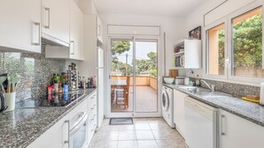 A modern kitchen with a built-in oven, a dishwasher, and a large window. - Holiday Home 'Pineda 12' with Mountain View, Private Pool and Wi-Fi (Pals)