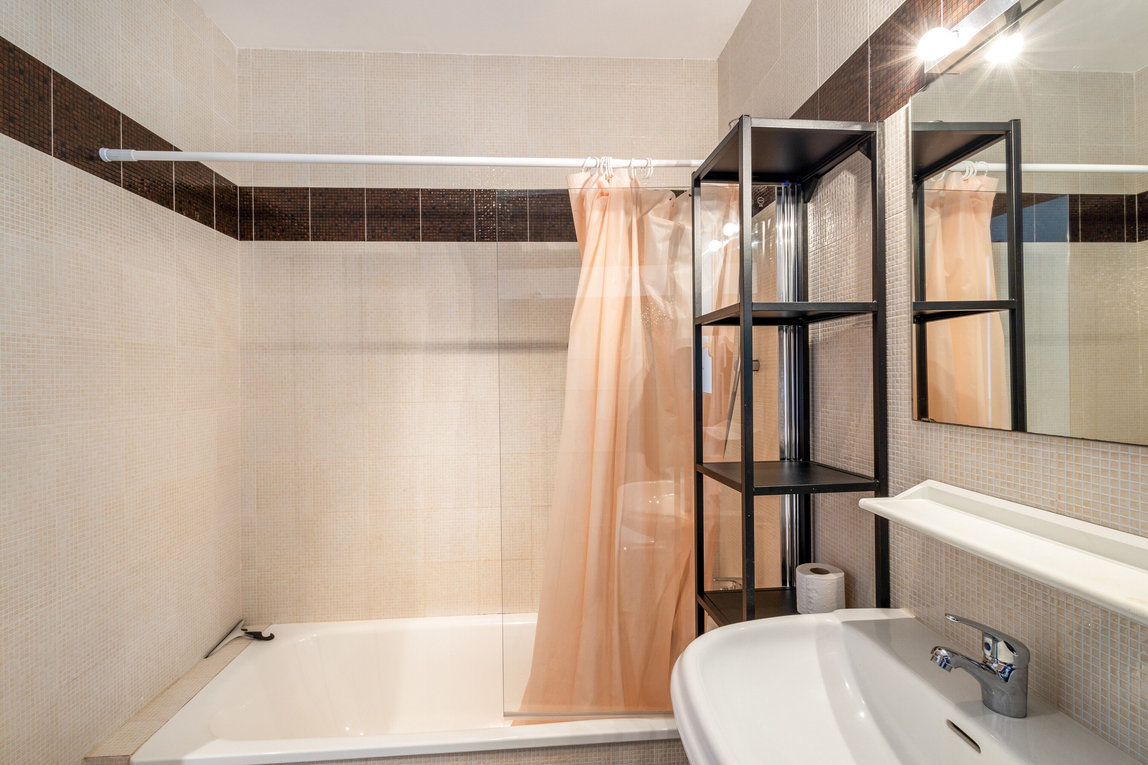Un baño moderno con cabina de ducha de vidrio, un lavabo blanco y un espejo sobre él.