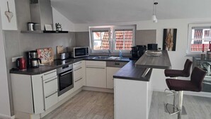 A modern kitchen with a microwave, toaster, and coffee maker. - Cozy vacation apartment close to the beach (Juist)