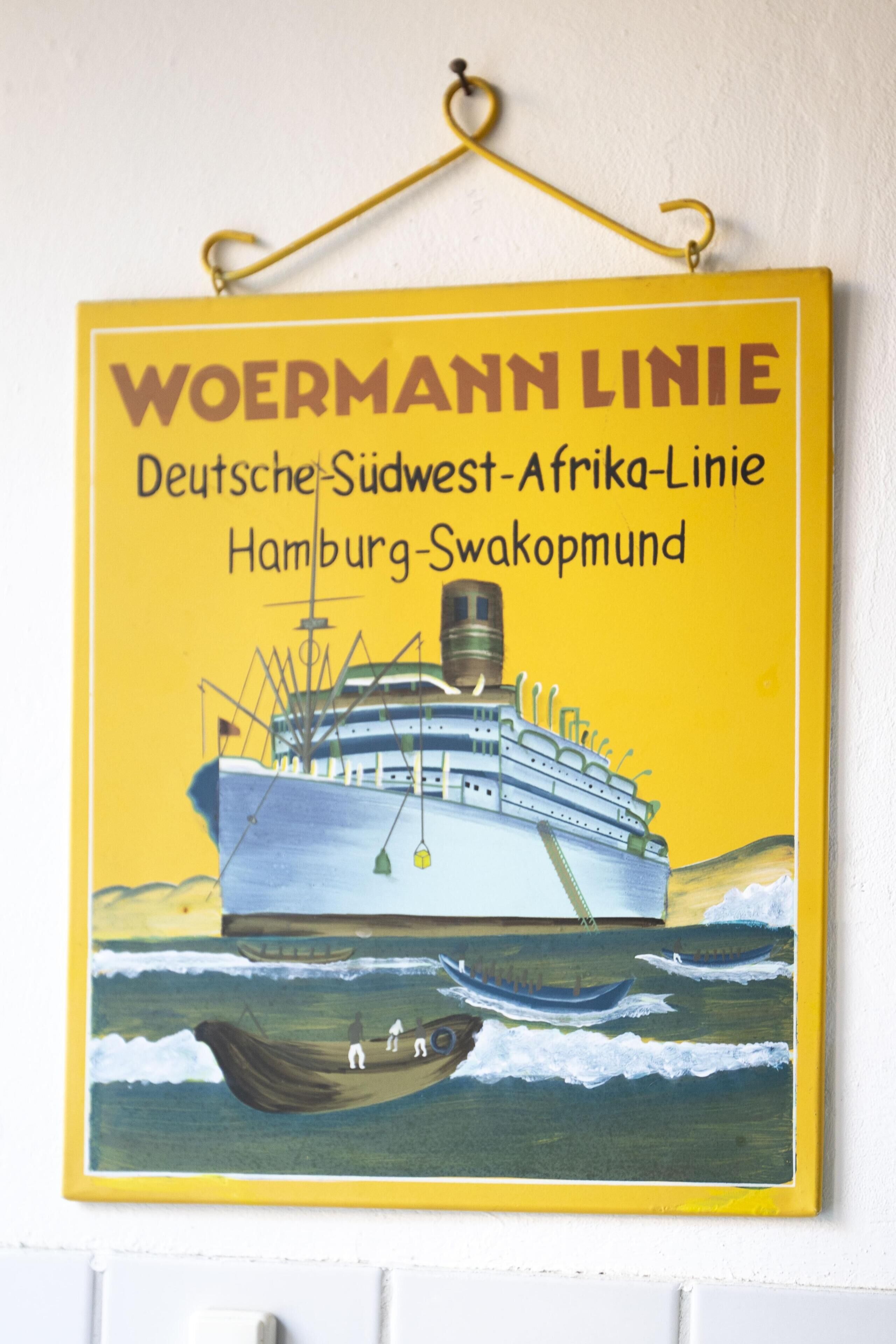 A yellow sign with a ship illustration and text indicating a travel route.