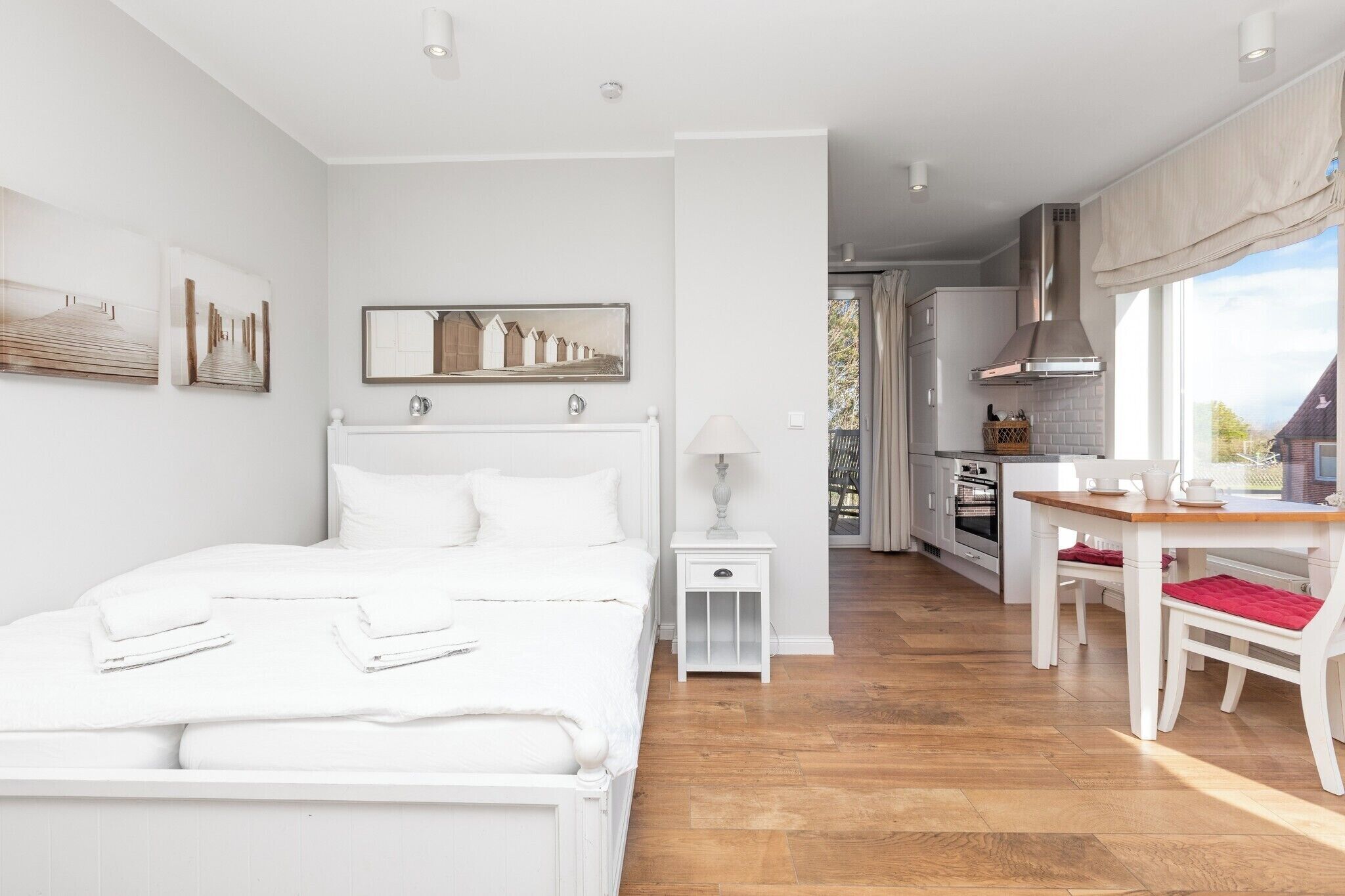 Une chambre à coucher avec un lit, une table de chevet et une vue sur la cuisine.