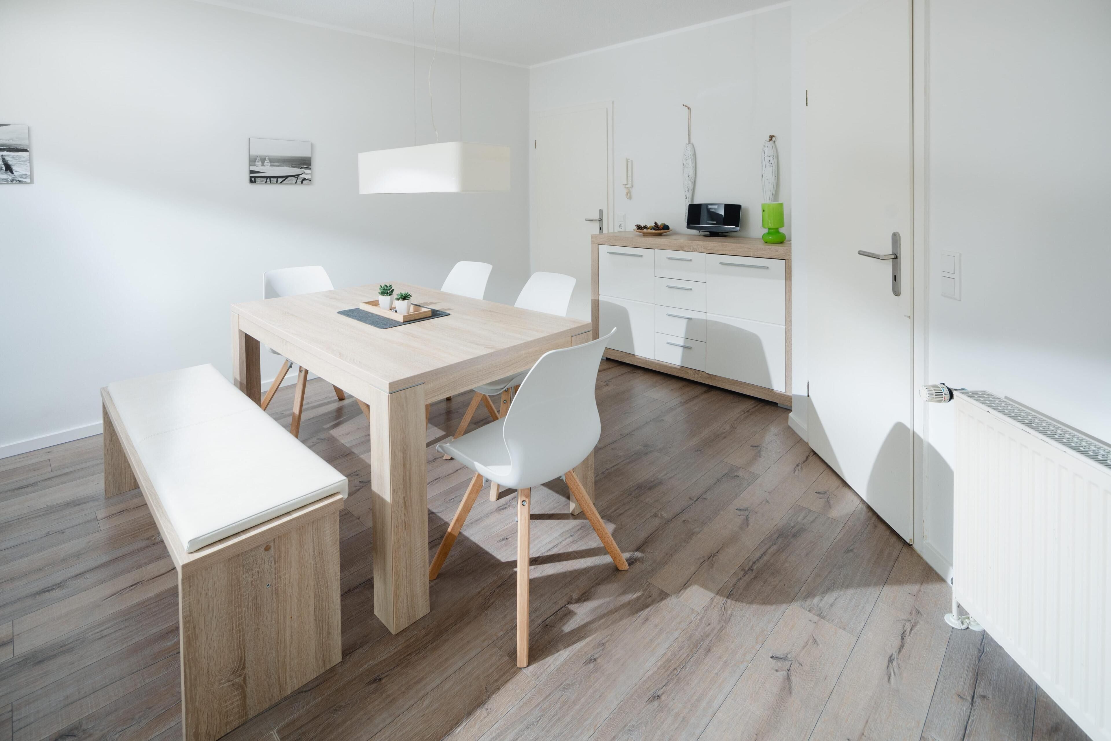 Una cucina moderna con mobili bianchi, un piano di lavoro in legno e un forno a microonde.