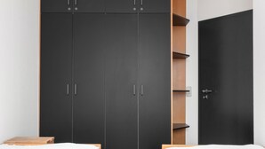 Ein Schlafzimmer mit zwei Betten, einem Kleiderschrank und einer Tür.