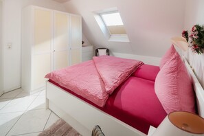 A bedroom with a bed, a wardrobe, a desk, a chair, and a skylight. - "Fantastic apartment with sea view and leisure facilities in Juist!" (Juist)