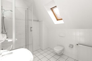 Un baño moderno con tragaluz, ducha, inodoro y lavamanos.