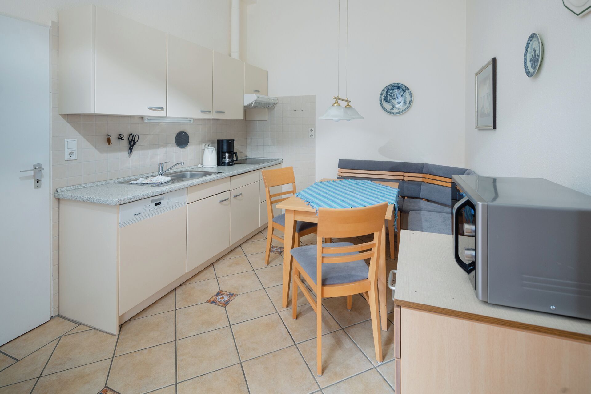 A compact kitchen with a dining area, a coffee maker, and a microwave.