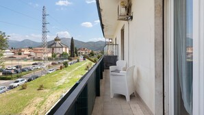 A balcony with a view of a street and mountains, a white chair, and a small table. - Holiday Home Villanova (Villanova)