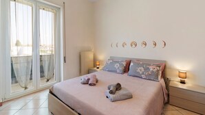 A bedroom with a bed, two bedside tables, a nightstand, a window with curtains, and a wall with moon phases. - Holiday Home Villanova (Villanova)