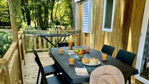 Eine Holzterrasse mit einem Esstisch und Stühlen.