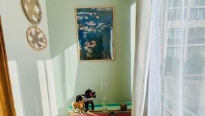 A room with a table, a painting, and a window with curtains. - Comfortable apartment near the center - 4 guests (Amélie-les-Bains-Palalda)