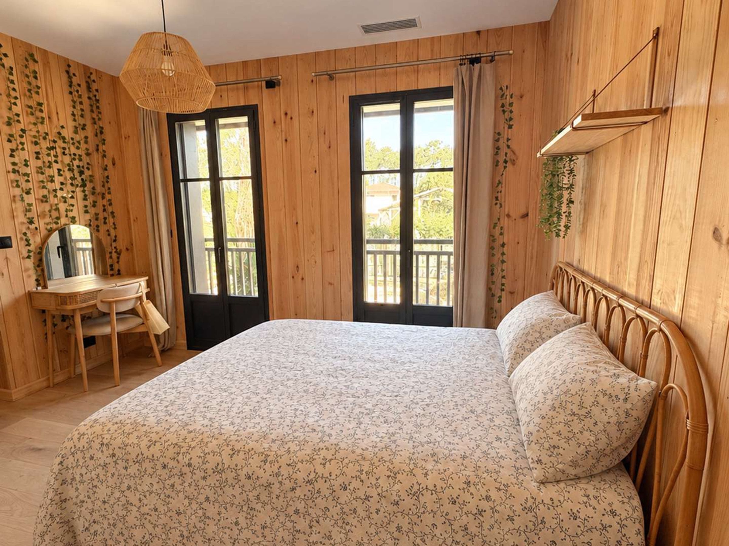Ein Zimmer mit einem Bett, einem Schreibtisch und einem Fenster mit Vorhängen.