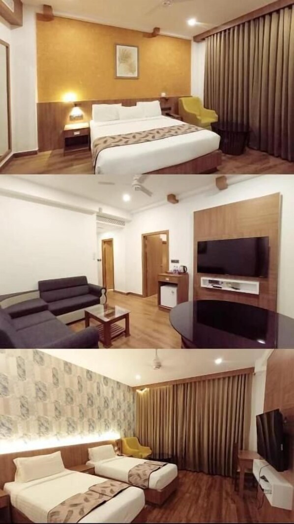 A hotel room with a bed, a sofa, a TV, and a desk. - SKY PENTA RESIDENCY (Iritty)