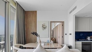 Un salon moderne avec un canapé, une table à manger et une vue sur la ville.