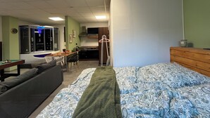 A compact room with a bed, a sofa, a kitchenette, and a small dining area. - Modern SPA studio in the heart of Gehrden (Gehrden)