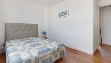 Une chambre à coucher avec un lit, une table de chevet, une lampe et un tableau encadré au mur.