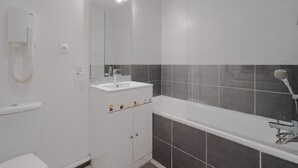 A modern bathroom with a toilet, sink, mirror, shower, and a towel rack. - Saint Clair Ndeg318 - ST3 (Agde)