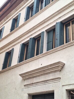 A multi-story building with a classical architectural style, featuring evenly spaced windows with shutters, a clean facade, and a visible door at the bottom. - 206 - Stube Room (Belluno)