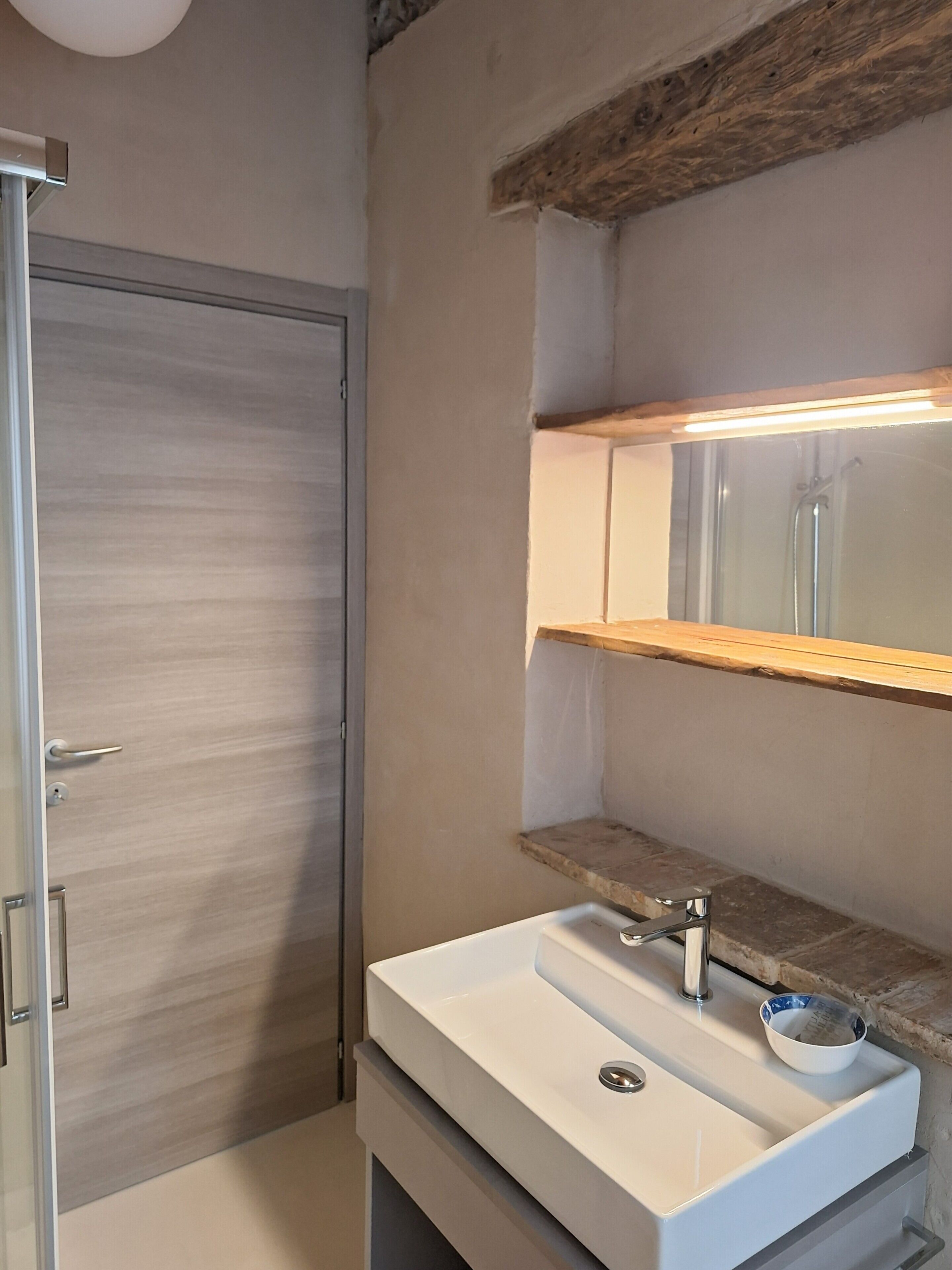 Ein Badezimmer mit Waschbecken, Spiegel und Dusche.