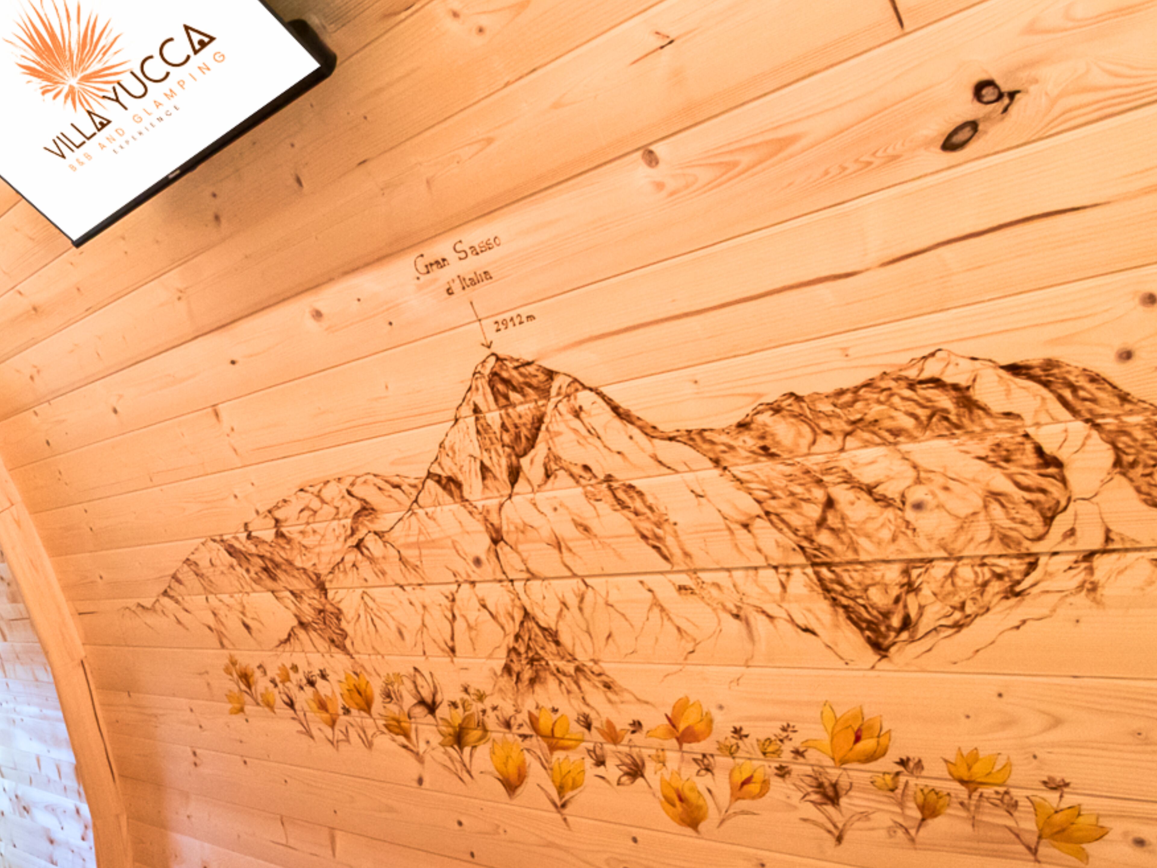 Techo de madera con un mural de paisaje montañoso, un logo y un indicador de distancia.