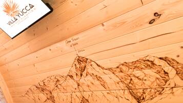 Techo de madera con un mural de paisaje montañoso, un logo y un indicador de distancia.