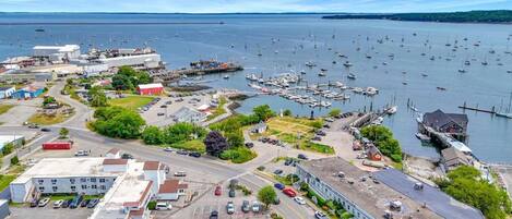 Un puerto deportivo con barcos, un estacionamiento y edificios.