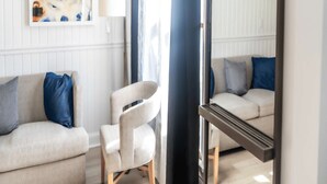 A room with a sofa, chair, and a large mirror. - King + Sofa w/ Balcony + Free Breakfast & Parking (Rockland)