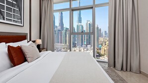 Une chambre d’hôtel avec une grande fenêtre, un lit et une vue sur le paysage urbain.