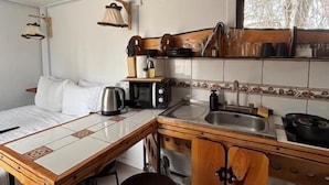 Una cocina compacta con comedor, microondas, hervidor de agua y pileta.