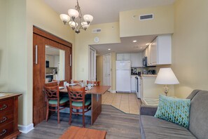 A compact living space with a dining area, kitchenette, and a sofa with a patterned pillow. - HS-0823 8th Fl Ocean Retreat | Pools | Lazy River (Myrtle Beach)