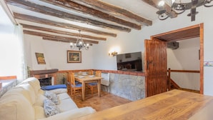 Un ambiente acogedor con una mesa de madera, un sofá y una chimenea.