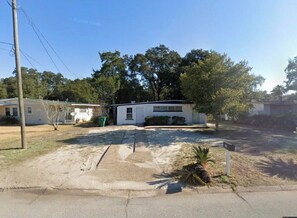 A residential area with a white house, a driveway, and a palm tree. - 3-bedroom house in enchanting Fort Walton Beach with AC (Fort Walton Beach)