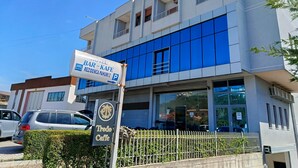 A modern building with a sign for a bar and cafe, a parking sign, and a cafe named 'Tredo Caffe'. - Rezidenca Pahumi 2 (Durrës)