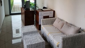 A reception area with a reception desk, a sofa, and a small table. There is a window with a view of the street and a building labeled 'LAVAZH'. - Rezidenca Pahumi 2 (Durrës)