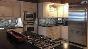 Una cocina moderna con estufa a gas, electrodomésticos de acero inoxidable y armarios de madera.