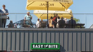 Un edificio con un letrero que dice 'EASY BITE' y un paraguas amarillo encima.