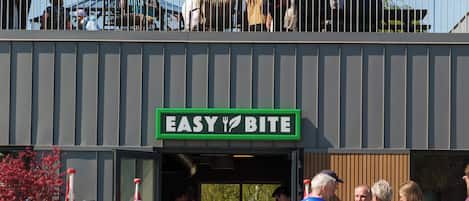 A building with a sign reading 'EASY BITE' and a yellow umbrella above.