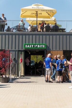 A building with a sign reading 'EASY BITE' and a yellow umbrella above. - Easy Stay Næstved (Næstved)