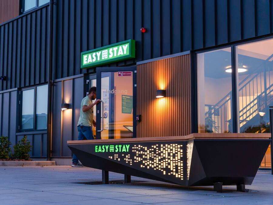 A modern building with a sign reading 'EASY STAY' above the entrance.